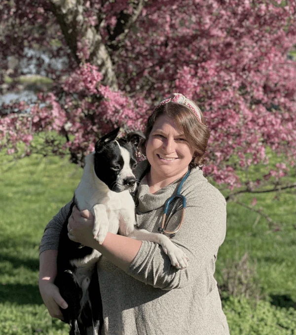 Dr. Morgan Elser holding a dog outdoors